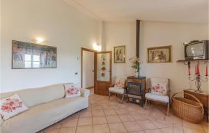 ein Wohnzimmer mit einem Sofa, 2 Stühlen und einem TV in der Unterkunft La Querciola in Seggiano