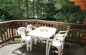 Una mesa blanca y sillas en una terraza de madera. en Holiday Home Gotti - 08, en Vecoux