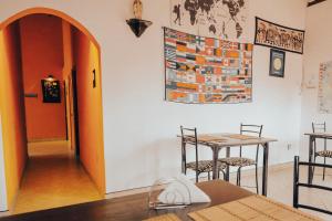 ネゴンボにあるLilly Palace Villa Guest Houseのオレンジのドア、テーブルと椅子が備わる客室です。