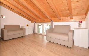 two chairs in a living room with wooden ceilings at Pescau House in Lezzeno