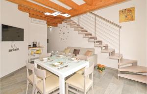 a dining room with a white table and a staircase at Pescau House in Lezzeno