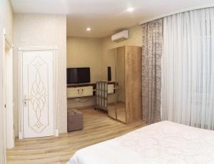a bedroom with a bed and a tv and a door at MidCity Hotel in Baku