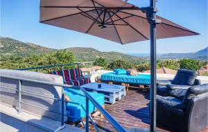 a patio with a table and chairs and an umbrella at Beautiful Home In Calenzana With 3 Bedrooms, Wifi And Outdoor Swimming Pool in Calenzana