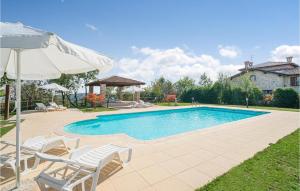 a swimming pool with two chairs and an umbrella at Mimosa 1 in Salsomaggiore Terme