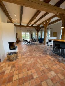 una gran sala de estar con chimenea y mesas. en Ferienhaus am Wasserschloss Haus Marck, en Tecklenburg