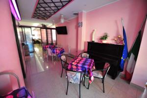 Hotel Nascente في ريتشيوني: غرفة بجدران وردية وبيانو وكراسي
