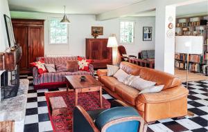 a living room with leather furniture and a dog sitting on a couch at 3 Bedroom Nice Home In Clohars-Carnoet in Keranquernat