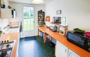 a kitchen with a counter with a sink and a stove at 3 Bedroom Nice Home In Clohars-Carnoet in Keranquernat