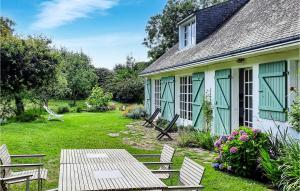 a house with a table and chairs in the yard at 3 Bedroom Nice Home In Clohars-Carnoet in Keranquernat