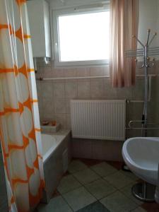 a bathroom with a tub and a sink and a window at Mézeskuckó in Tiszaszőlős