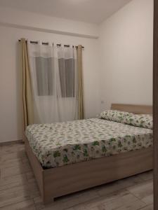薩爾雷的住宿－Rosa dei Venti Apartment 50meter beach front，一间卧室配有一张床和被子