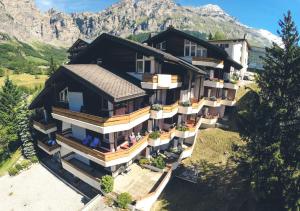 eine Luftansicht eines Hauses mit Bergen im Hintergrund in der Unterkunft Hotel Alpenblick-Leukerbad-Therme in Leukerbad