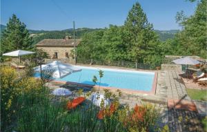 una piscina con sombrillas en un patio en Amazing Home In Apecchio -pu- With Kitchen, en Apecchio
