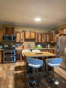 a kitchen with wooden cabinets and a island with bar stools at paradise cove in Spanish Town