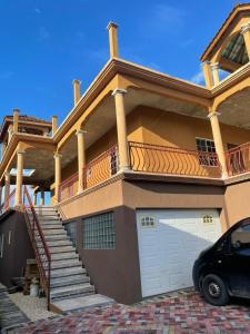 a house with a car parked in front of it at paradise cove in Spanish Town