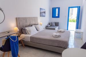 Schlafzimmer mit einem Bett, einem Schreibtisch und einem Stuhl in der Unterkunft Fragoulis Village in Parasporos