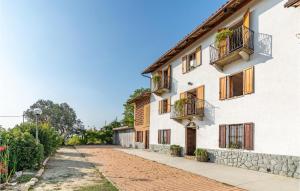 an empty street in front of a white building at 2 Bedroom Awesome Home In Priocca in Priocca
