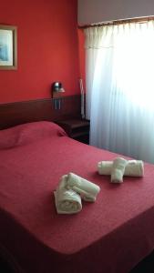 a red bedroom with two towels on a bed at Hotel Lantaño in Mar de Ajó