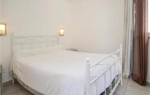 a white bed in a bedroom with a white bed frame at Nice Apartment In Moriani Plage in Moriani Plage +7 photos
