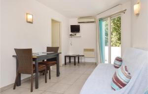a room with a bed and a desk and a bed and a table at Nice Apartment In Moriani Plage in Moriani Plage