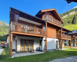 a house in the mountains with a balcony at Jana 4 by SMR Rauris Apartments - inc Spa and National Summercard - near Gondola in Rauris