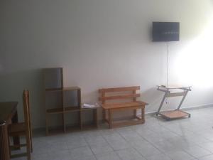 Habitación con mesa, banco y TV. en Hotel Azulejos, en Chachalacas