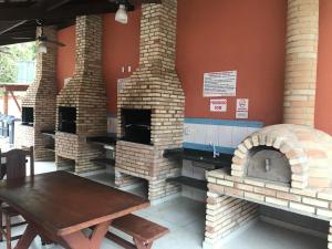 eine Terrasse mit drei gemauerten Öfen in einem Restaurant in der Unterkunft SUN Flat Maresias !! 2 Quartos Piscina Churrasqueira WiFi Estacionamento 230m da Praia in São Sebastião