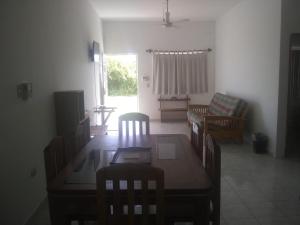 sala de estar con mesa de madera y sillas en Hotel Azulejos, en Chachalacas