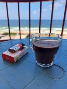 una taza de café sentada en una mesa cerca de la playa en family condo with panoramic sea view, en Alejandría