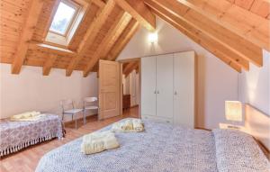 a bedroom with two beds in a room with wooden ceilings at 3 Bedroom Beautiful Home In Ovaro Ud in Pesariis