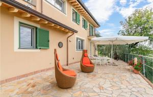 eine Terrasse mit orangefarbenen Stühlen und einem Sonnenschirm in der Unterkunft La Stallina in Culla