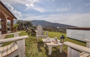 un patio avec une table et des chaises sur l'herbe dans l'établissement Villa Maia, à Scarlino