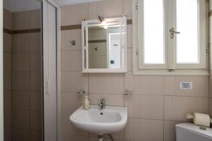 a bathroom with a sink and a mirror and a toilet at Akrothalassia in Adamantas +37 photos