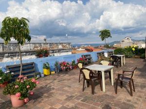a patio with tables and chairs on a roof at Check Inn Bed and Breakfast in Cuenca