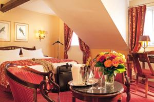 فندق دو فارين في باريس: غرفة في الفندق بها سرير وطاولة بها زهور