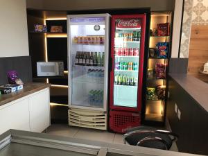 a coca cola refrigerator in a kitchen at Vespasiano Hotel Telêmaco Borba in Telêmaco Borba