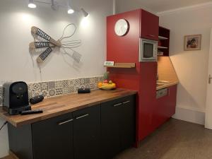 eine Küche mit einem roten Kühlschrank und einer Mikrowelle in der Unterkunft Sanary Bandol Piscine Plage Calme in Sanary-sur-Mer