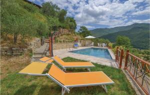 a swimming pool with two benches next to a mountain at Casa Di Vigna Rosa in Serravalle