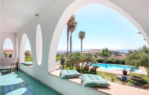 een kamer met uitzicht op een zwembad en palmbomen bij Villa Curreri in Porto Palo