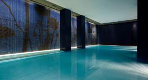 a swimming pool in a building with a mosaic wall at Mamilla Hotel in Jerusalem