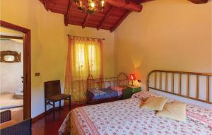 een slaapkamer met een bed, een stoel en een raam bij Lovely Apartment In Casoli Lu With Kitchen in Cocciglia