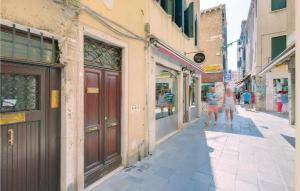 a couple of people walking down a street at Stunning Apartment In Venezia -Ve- in Venice