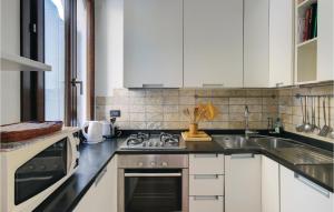 a kitchen with white cabinets and a sink at Stunning Apartment In Venezia -Ve- in Venice +13 photos