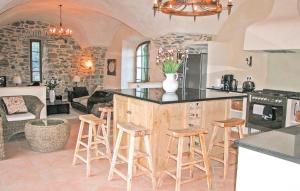 a kitchen with a island and stools in a room at Stunning Home In Anduze With 5 Bedrooms, Internet And Outdoor Swimming Pool in Anduze