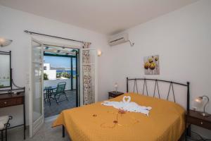 a bedroom with a bed with a yellow bedspread at Akrothalassia in Adamantas