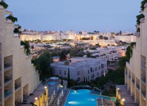 una vista di una città di notte con edifici di The David Citadel Jerusalem a Gerusalemme