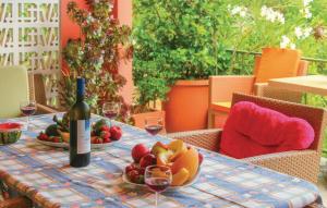 a table with a bottle of wine and a bowl of fruit at Stunning Home In Artemida With 3 Bedrooms And Wifi in Artemida