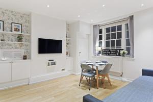 a living room with a table and a tv at Trendy 1 Bedroom Apartment in the Heart of London in London