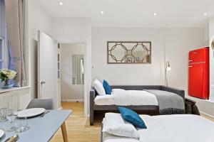 a living room with two beds and a table at Trendy 1 Bedroom Apartment in the Heart of London in London