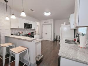 a kitchen with white cabinets and a counter top at THE FARMHOUSE - FAMILY FRIENDLY DOWNTOWN COTTAGE in San Antonio